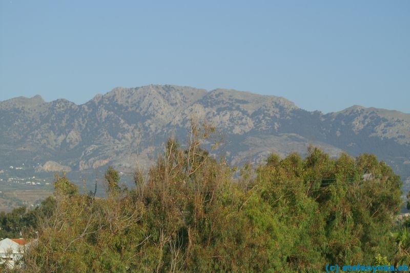Kos, Dikti z Marmari. Chodník na najvyšší vrchol Dikti vedie približne zo stredu fotografie (dedina Zia) vpravo hore do výrazného sedla a odtiaľ naspäť vľavo na vrchol