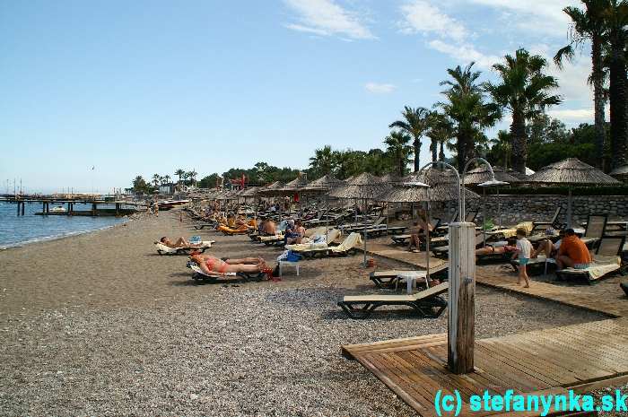 Pohľad z ľavého móla na pláži hotela Champion Holiday Village, Beldibi. Sprcha so sladkou vodou samozrejmosťou, osušky za jednorazový vratný depozit, denná výmena zadarmo