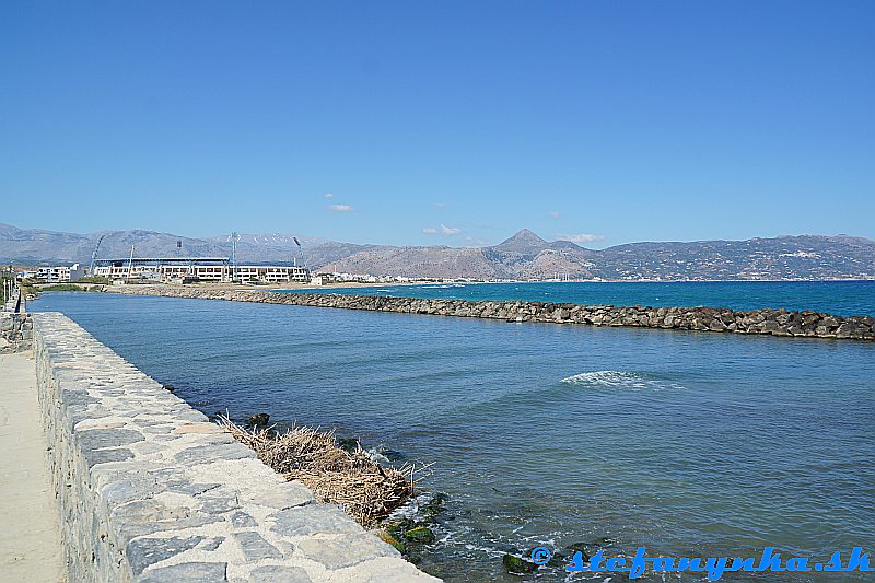 Heraklion. Pohľad na štadión a pláž Amoudary až po elektráreň. Nad pravým osvetlením štadióna je Psiloritis