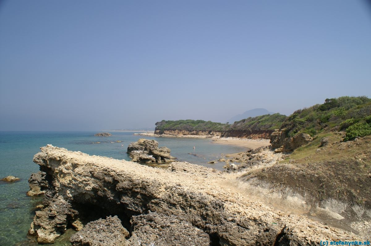 Agios Georgios south, Korfu. Za plávajúcou osobou sa nachádza vtok do jazera Korison. V pozadí kopec Pantokrator (ten južný)