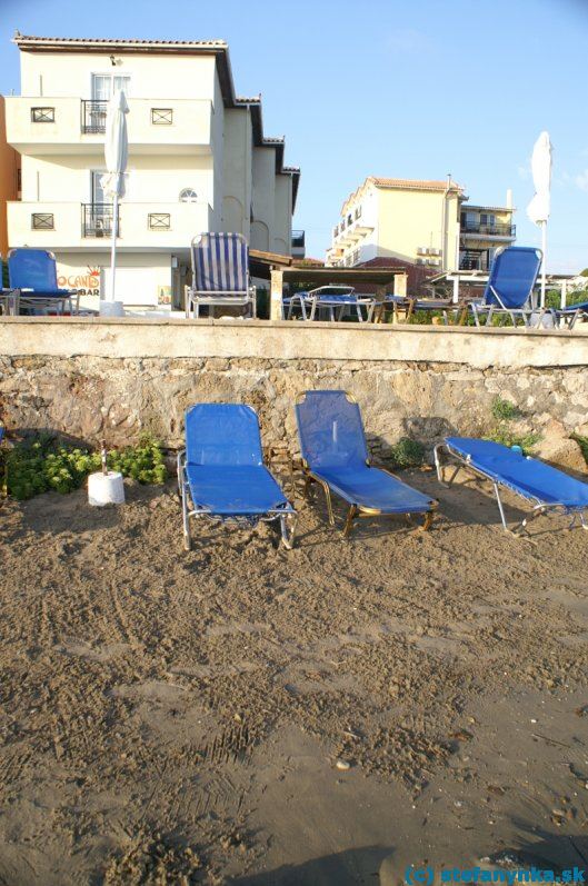 Zakyntos, hotel Locanda. Hotel Locanda v stredisku Argassi na ostrove Zakyntos. Fotené z úrovne mora, úzka pláž, horné lehátka sú pri bazéne. Recepcia a hlavné ubytovanie je v pravej budove, nejaké izby boli aj v ľavej budove.