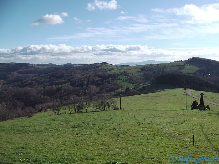 Pohľad od Vyškovca späť.  Vpravo na horizonte Kykula a Cesta hrdinov SNP pokračuje doľava po horizonte smerom na Machnáč (a ďalej do Trenčína...)