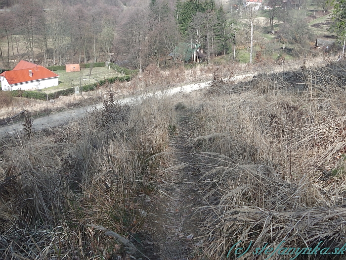 Vlčí vrch - Žítková. Chodník pokračuje k pravej stane plota a za ním prekračuje potok