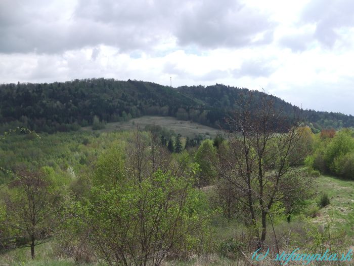 Breziny - pohľad naspäť. Stožiar ne na Zlatom vrchu. Približne pod ním na dolnom okraji lesa je rozcestník Breziny